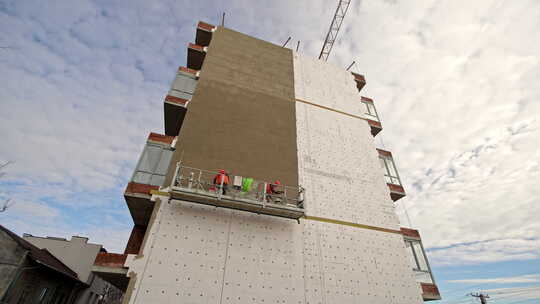高层建筑立面上的工人穿着安全背心的建筑工