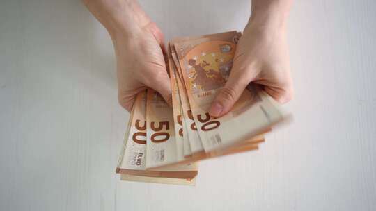计算欧元钞票时女性的手部特写欧洲经济的价值