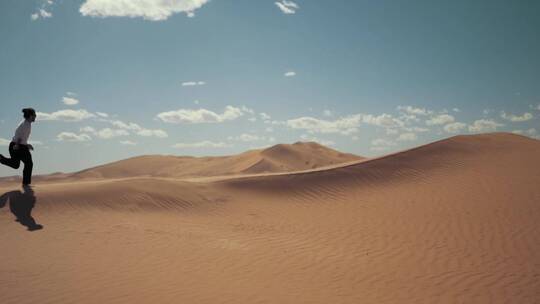 男人跑在沙漠的沙丘上