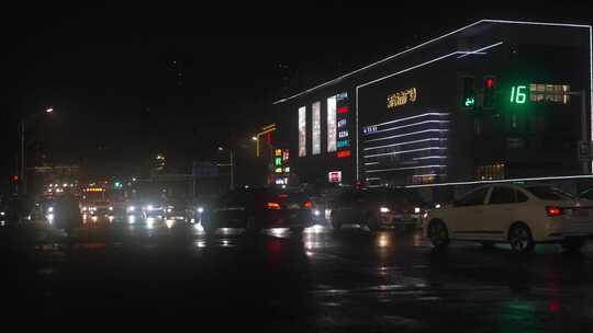 雨天夜晚城市马路上行驶的车辆