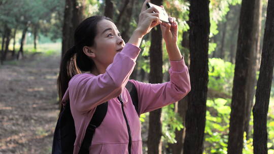 亚洲中国人女性森林树林旅游拿望远镜看风景