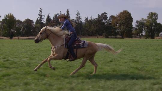 女人在草场快速的骑马