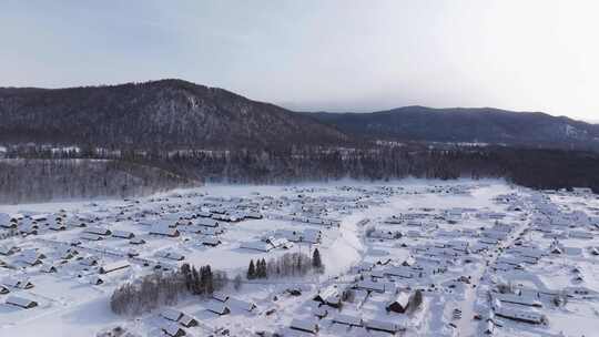 航拍新疆禾木雪景森林雪地小木屋禾木桥雪山