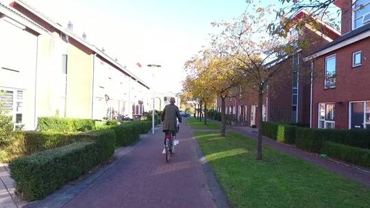 在城镇小路上骑自行车的人