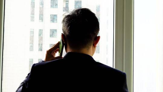 业务员公司窗前打电话联系客户推销业务剪影
