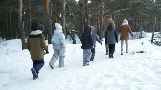 一家人在森林雪地上行走
