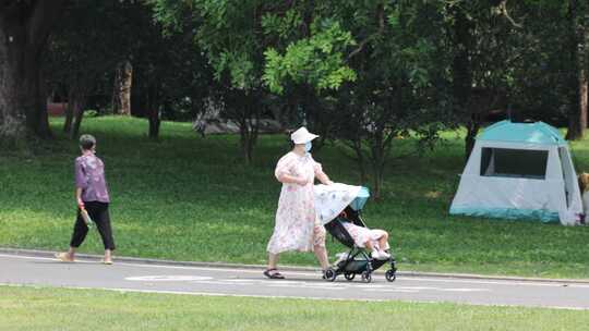母亲推着婴儿车在公园2视频素材模板下载