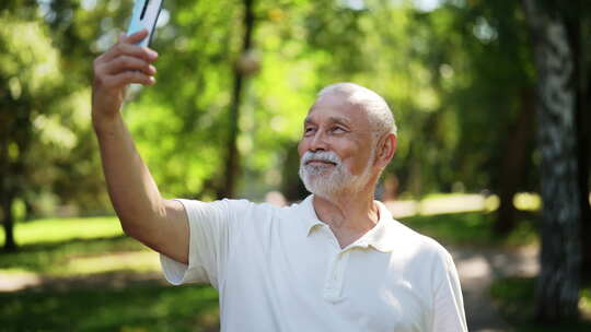 快乐的老人在夏季阳光明媚的公园散步时在智