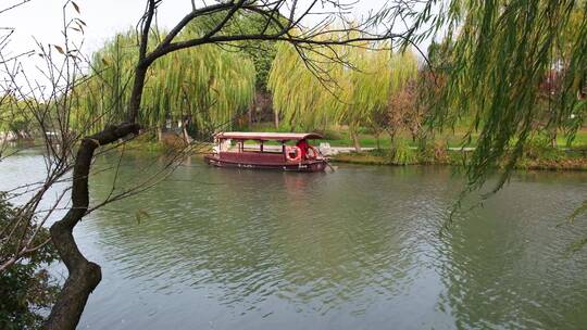 扬州瘦西湖阴雨天在雨中行驶的摇橹船及船娘