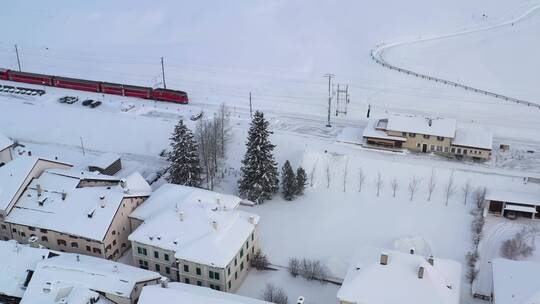 航拍铺满白色积雪地面铁轨上行驶的火车