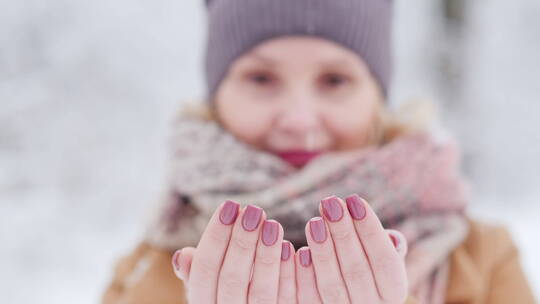 女人用双手接住漫天飘落的雪花