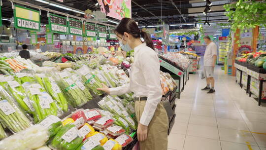 戴口罩的青年女人在超市选购蔬菜视频素材模板下载
