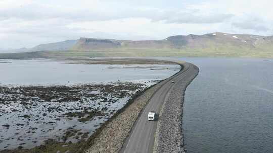 冰岛西峡湾水景中公路上行驶的车辆鸟瞰图。视频素材模板下载
