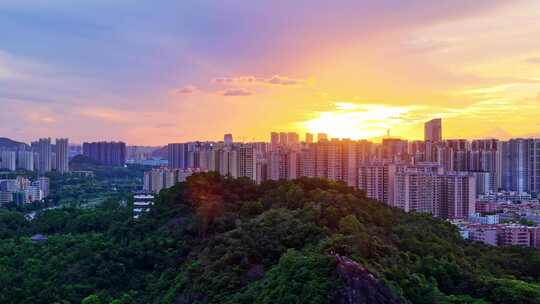 惠州大亚湾夕阳下的城市高楼与山林景观