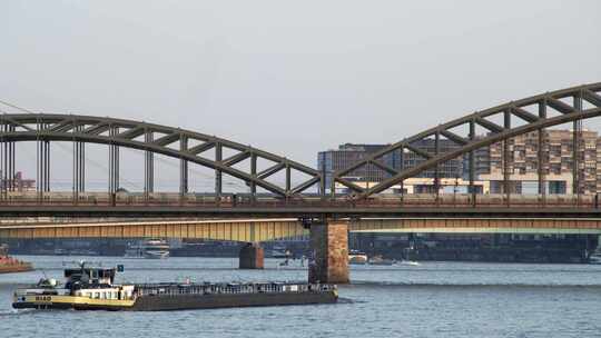 一辆油罐车从科隆的霍亨索伦大桥下驶过。在它上面，一辆ICE高速列车