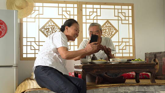 农民夫妇在家边吃饭边视频聊天