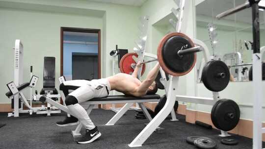 男子在健身房里锻炼举杠铃视频素材模板下载