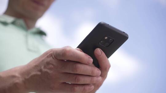 男子在室外玩手机刷手机视频素材模板下载