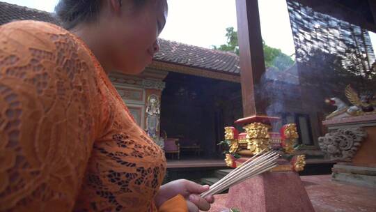 一名妇女在寺庙烧香