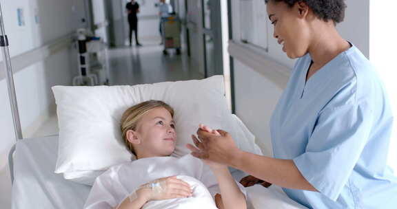 非裔美国护士在医院病床上照顾一个白人女孩