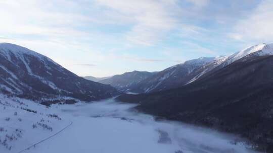 航拍新疆冬季喀纳斯河流晨雾雪山森林雪景