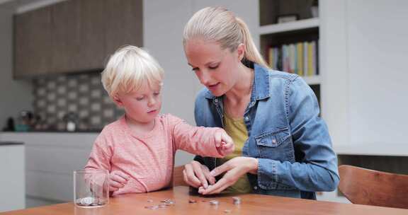 女人和孩子坐在桌子旁玩硬币