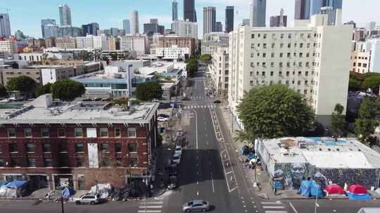 在建筑物之间的道路上移动汽车的无人机镜头