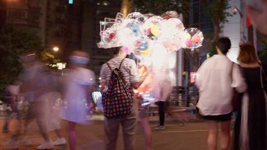 城市-人文-在川流不息的人群卖气球的商贩视频素材模板下载