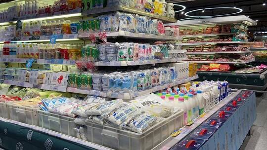 超市内部场景，零食、水果、牛奶货架商品