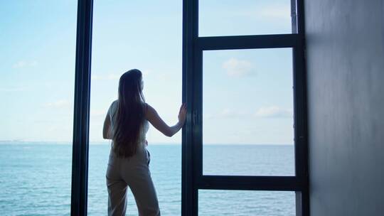 女人在窗边看海