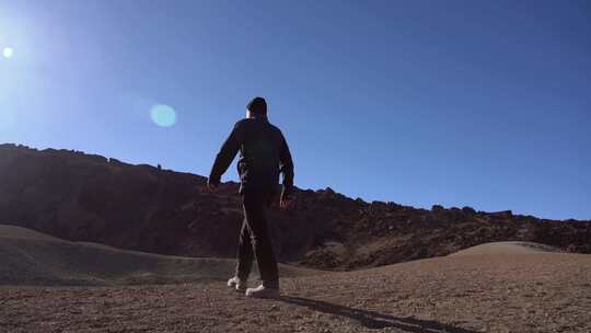 一个人爬上一座岩石山，环顾四周