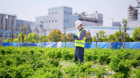 年轻工程技术人员拿着文件夹项目现场记录