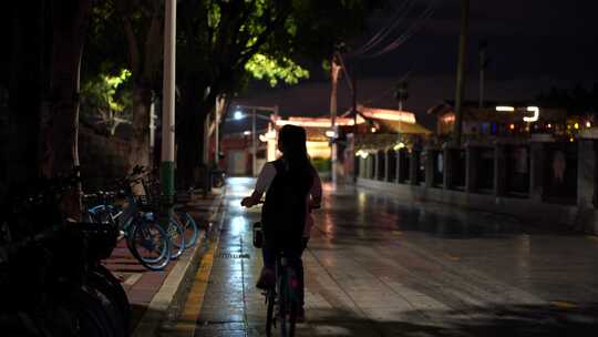 晚上下课后放学女学生骑自行车背影青春时代