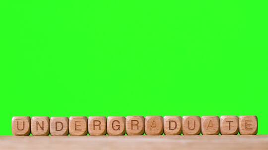 绿幕背景前的本科生对抗木块字母