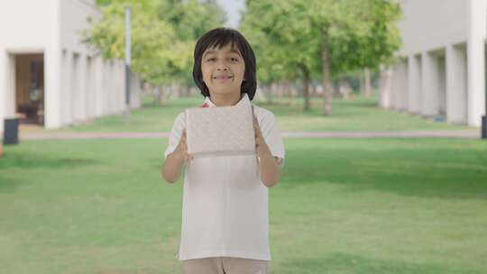快乐的印度男孩在公园里送礼物