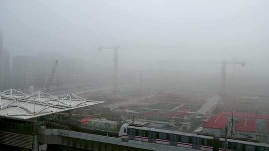 上海外高桥秋天晨雾地铁站与建设工地塔吊