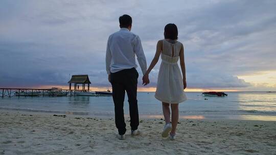 情侣牵手海边浪漫看夕阳晚霞