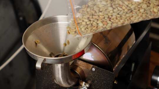咖啡豆烘焙过程，将未烘焙的生种子倒入咖啡