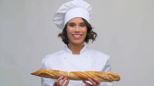 快乐女厨师展示法式面包
