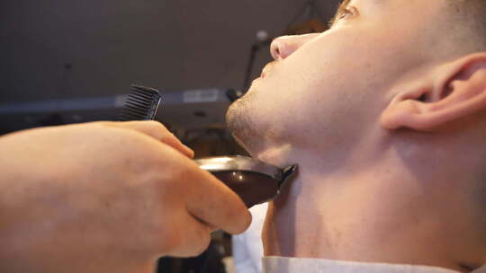 理发师用电动剃须刀修剪顾客胡须视频素材模板下载