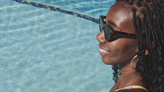 女人带着太阳镜在泳池中