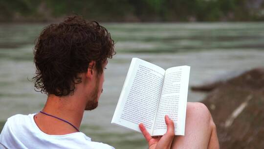 男人做在河边读书