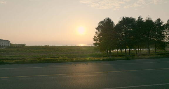 夕阳下环湖公路车辆行驶