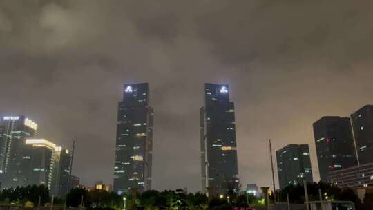 夜晚阴雨天双子塔高楼建筑下摇变焦