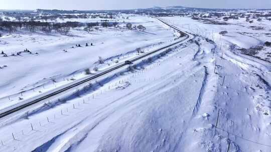 被白雪覆盖的广袤原野及蜿蜒道路