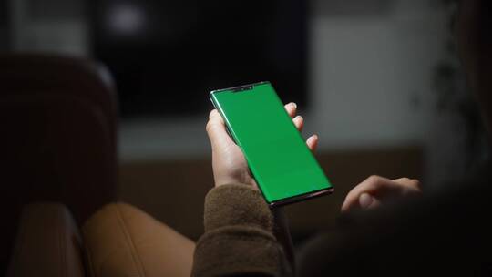 女性使用绿色绿幕抠像替换屏幕手机