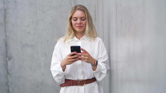 专业女性在户外智能手机上发短信