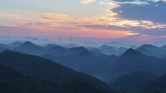 航拍大山顶上清晨云雾环绕日出风力发电风车