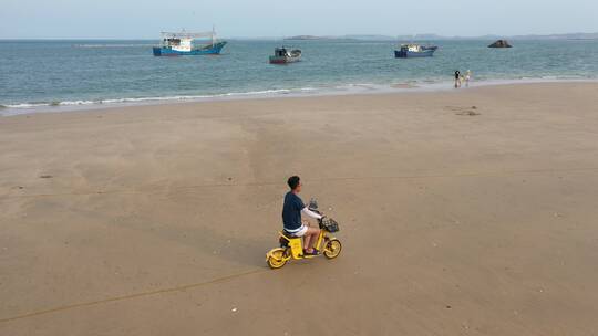 航拍福建平潭海边的沙滩人在骑车