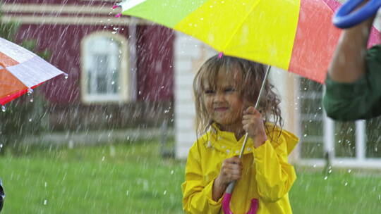 可爱的女孩撑着雨伞在雨中玩耍视频素材模板下载